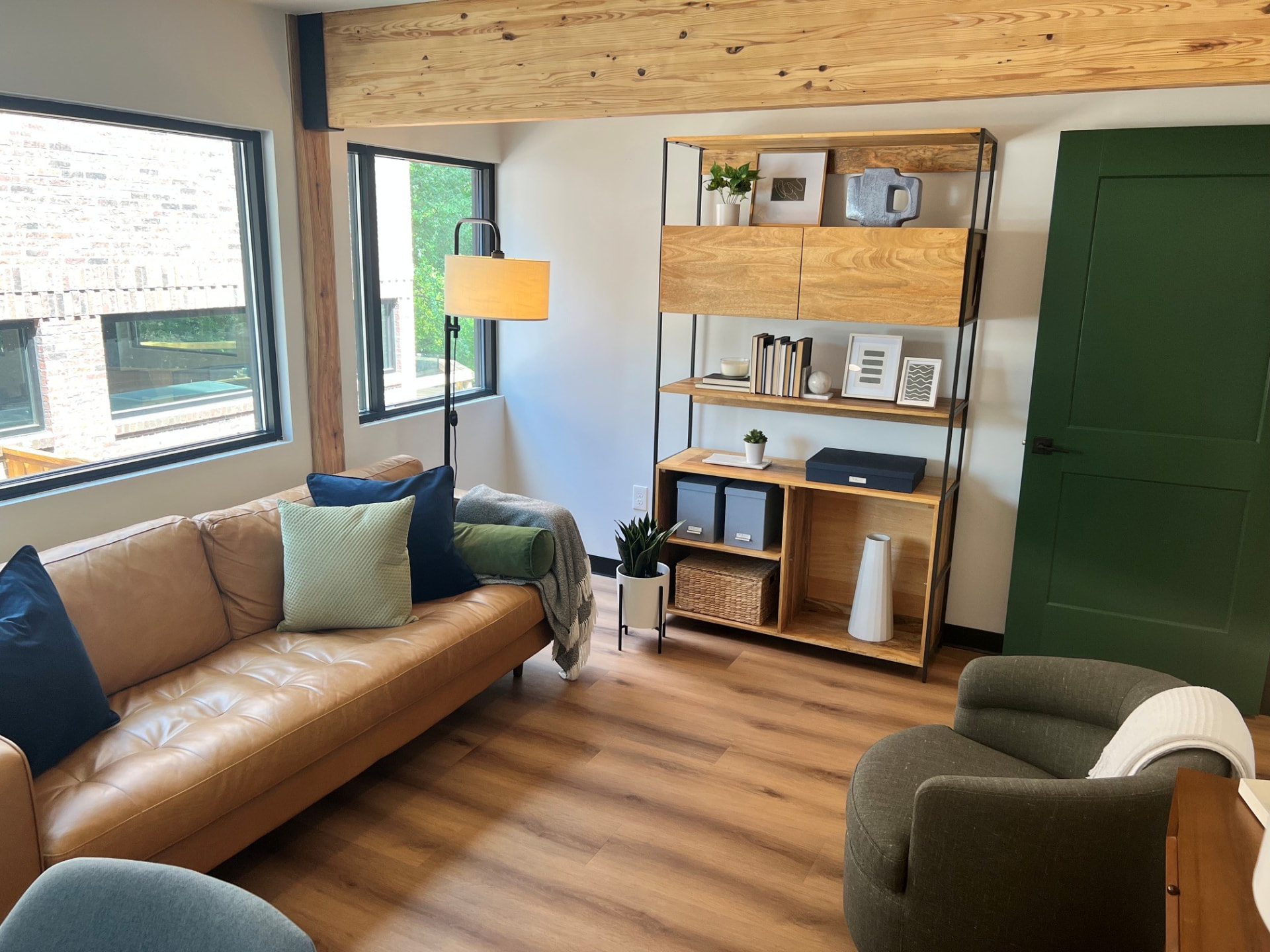 A therapy room at the Dallas Therapy Associates Dallas office — tan leather sofa, exposed wood beam, and warm natural light